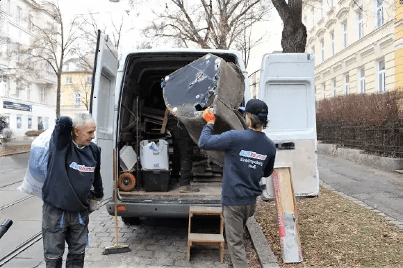 AUSRäumer Team lädt Möbel in den Transporter bei einer Entrümpelung in Wien